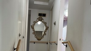 A hallway with marble flooring, a mirror with an ornate frame, and wooden handrails. - Charming 3-bedroom house in Pleasant Hinsdale with WiFi (Hinsdale)