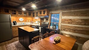 Una cocina rústica con armarios de madera, una isla central y una mesa de comedor con un florero.