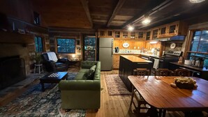Un acogedor interior de cabaña con sala de estar, comedor y cocina.