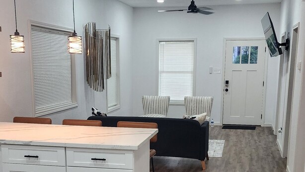 A spacious living area with a large white cabinet, a black sofa, and a dining table.