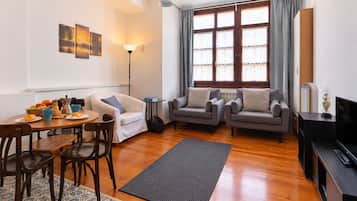Una sala de estar amoblada con comedor, sofá, mesa de centro y televisión.