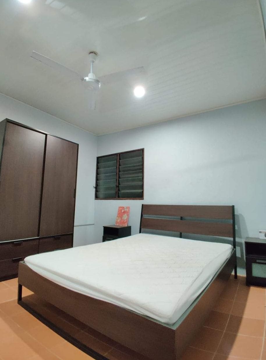 Un dormitorio con cama, armario, mesita de noche y ventilador de techo.