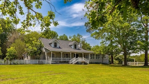 A two-story house with a porch, a staircase, and a fenced yard.