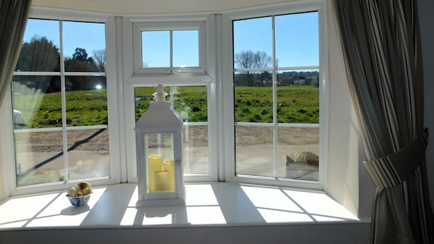 A bay window with a white lantern and a bowl of fruit.