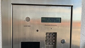 Ein metallisches Bedienfeld einer Aufzugskabine mit digitaler Anzeige, Tastenfeld und Knöpfen.