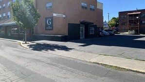 Ein Gebäude mit einem Schild, auf dem "G THE GEORGE" steht, und einem Parkplatz mit mehreren Autos.