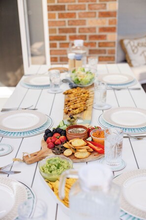Une table mise pour un repas, avec des assiettes, des verres et une variété de plats.
