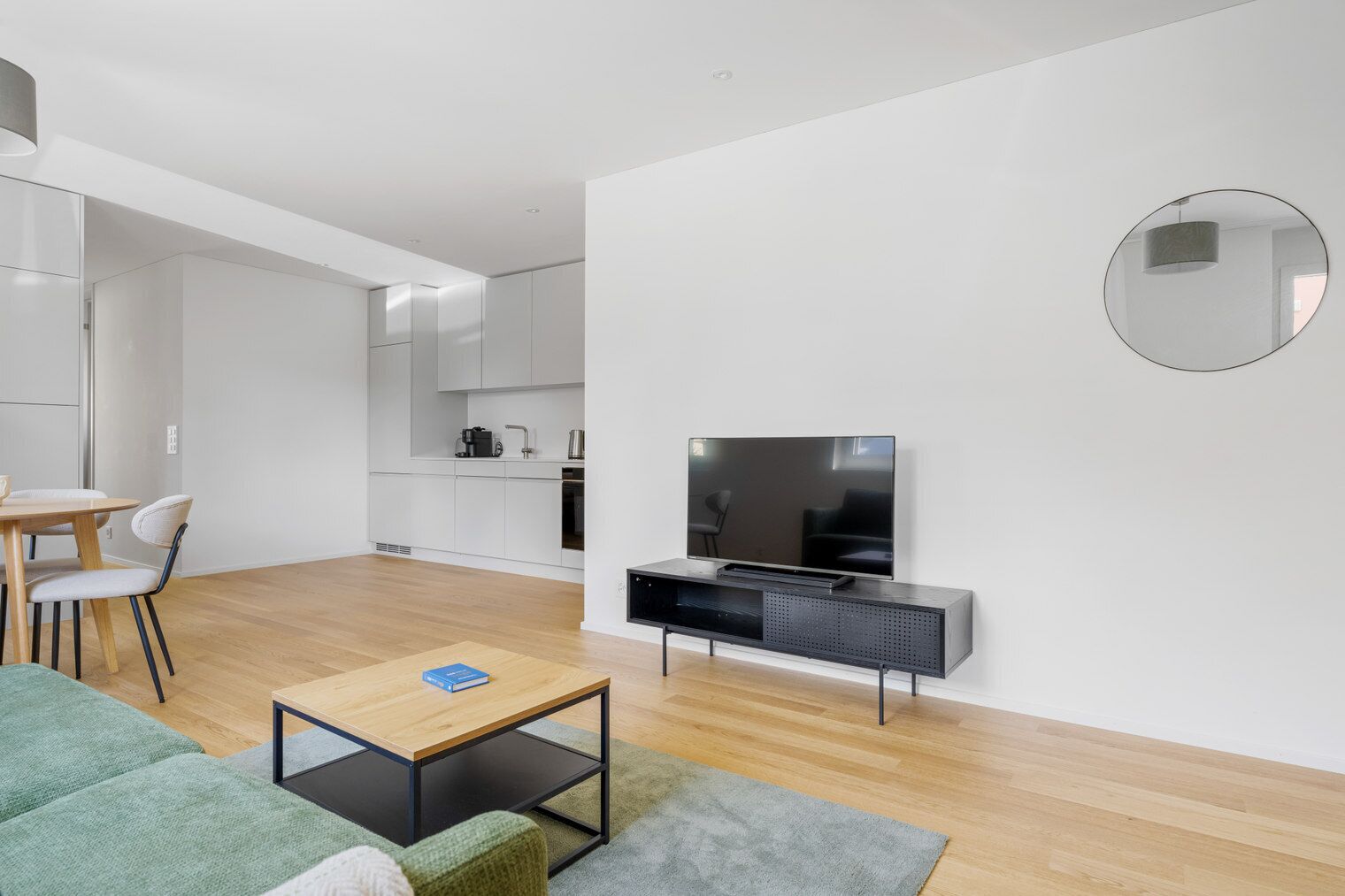 Un salon moderne avec un téléviseur à écran plat, une table basse et un canapé.