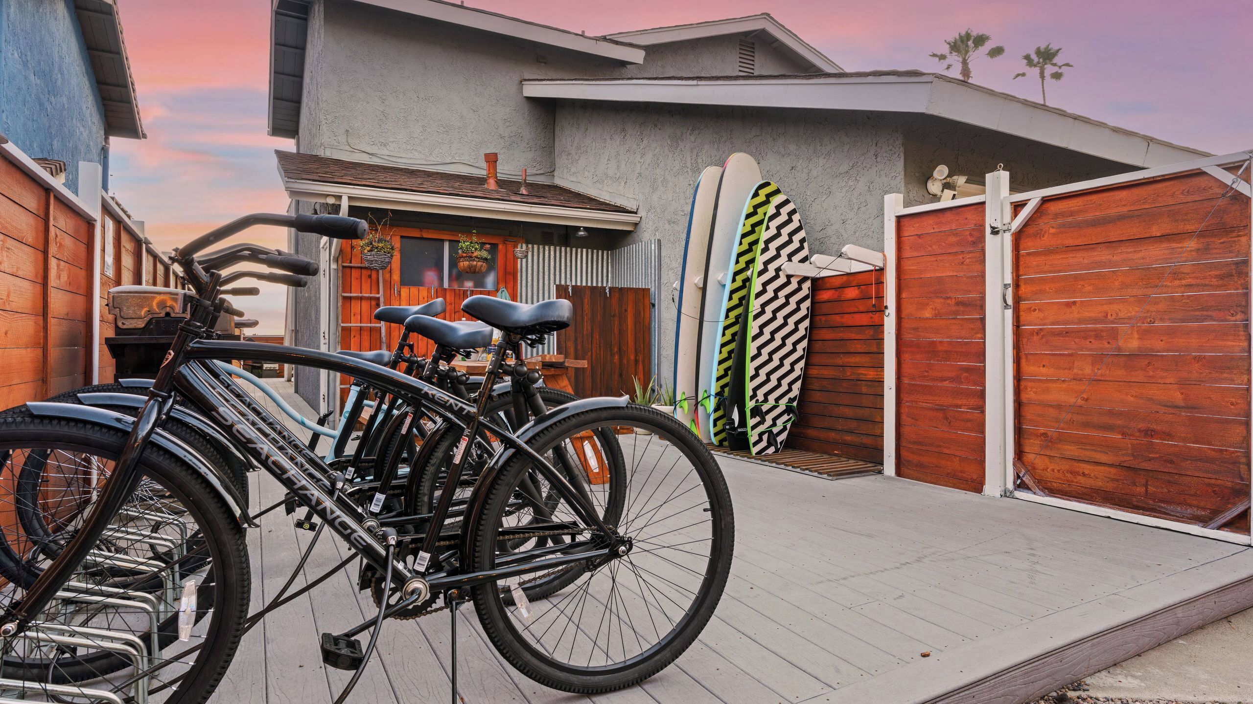 A residential area with a garage, bicycles, and surfboards.