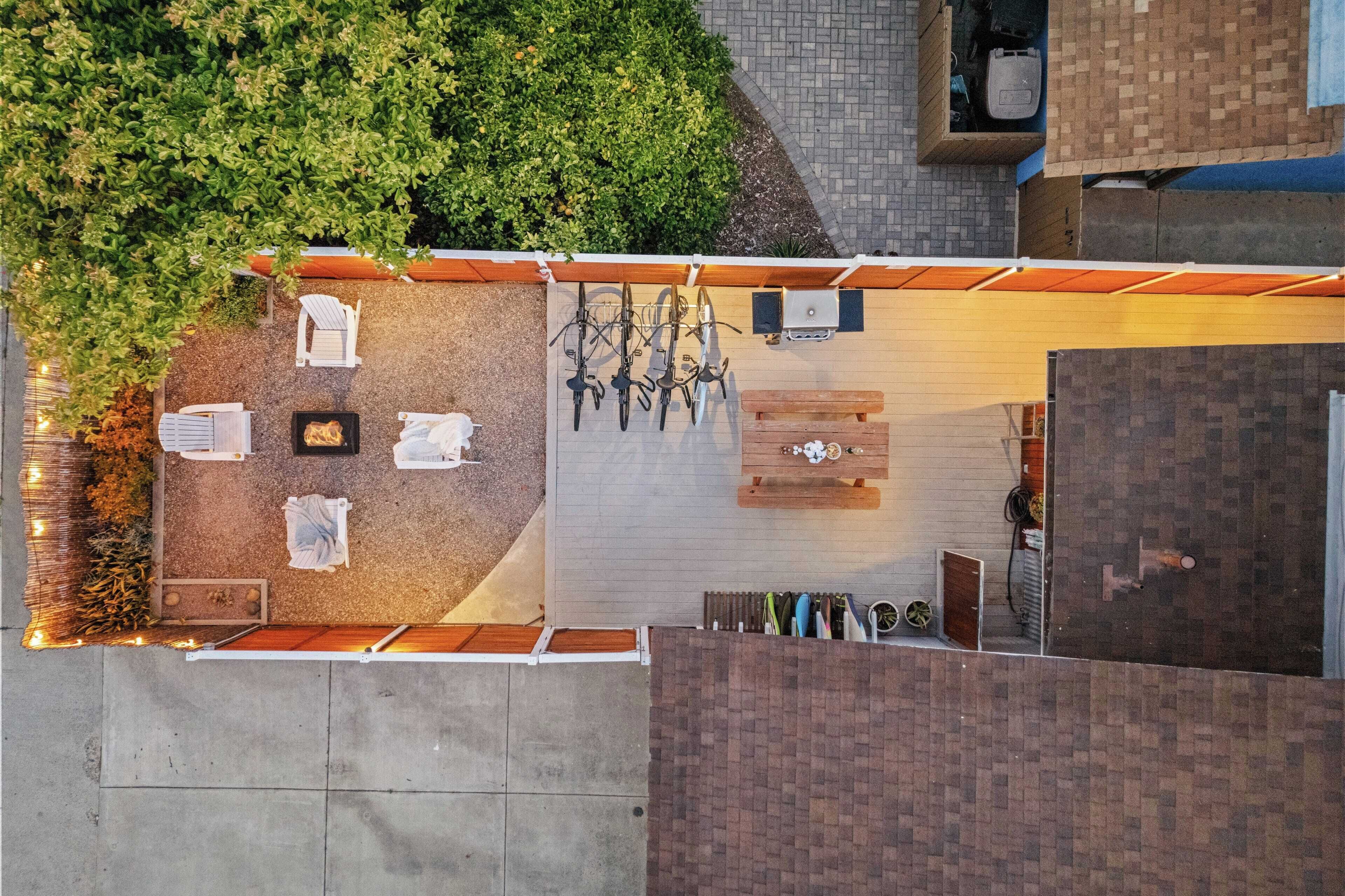 Un patio al aire libre con mobiliario, una parrilla y bicicletas.