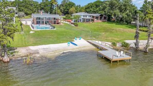 Ein Wohnhaus mit Schwimmbad, Bootsanleger und Rasenfläche.