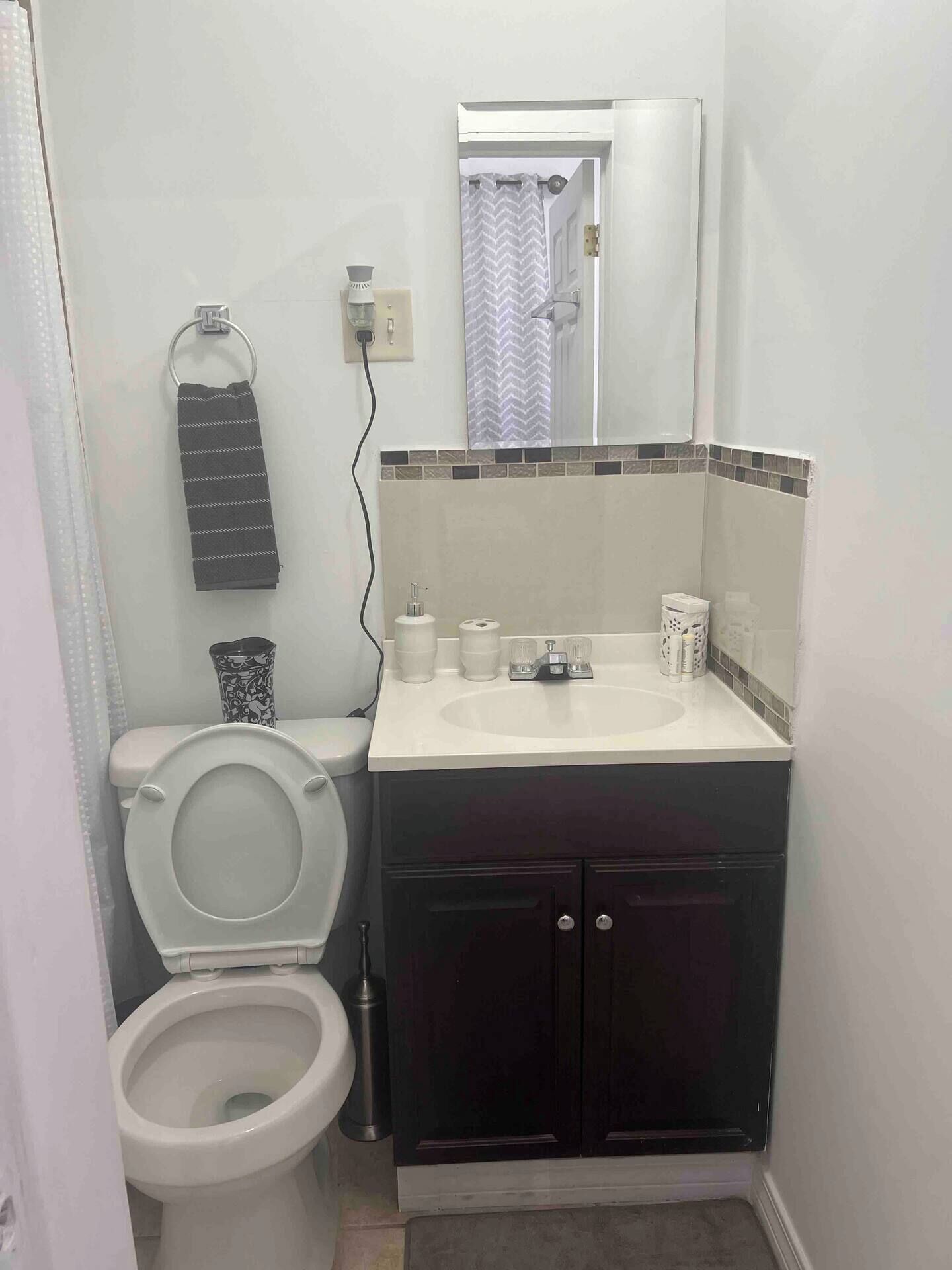Une petite salle de bain avec des toilettes, un lavabo et un miroir.