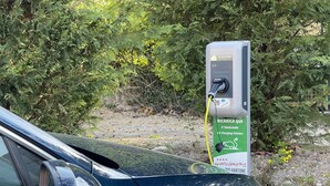 A car parked at an electric charging station with a green sign indicating it's a public charging point. - Mountain View Lodge XL (1) - Idro (Idro)