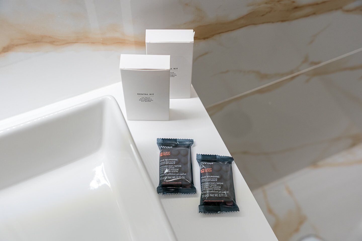 Un lavabo con un kit de higiene bucal y dos pastillas de jabón.