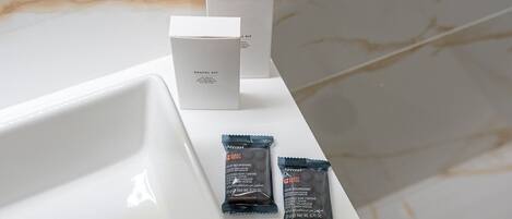 Un lavabo con un kit de higiene bucal y dos pastillas de jabón.