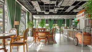 Un comedor moderno con mobiliario de madera, cortinas verdes y una barra.