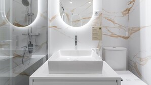 A modern bathroom with a large mirror, a white sink, and a shower enclosure. - GuestReady - Tutti Frutti Studio - Avocado (Porto)