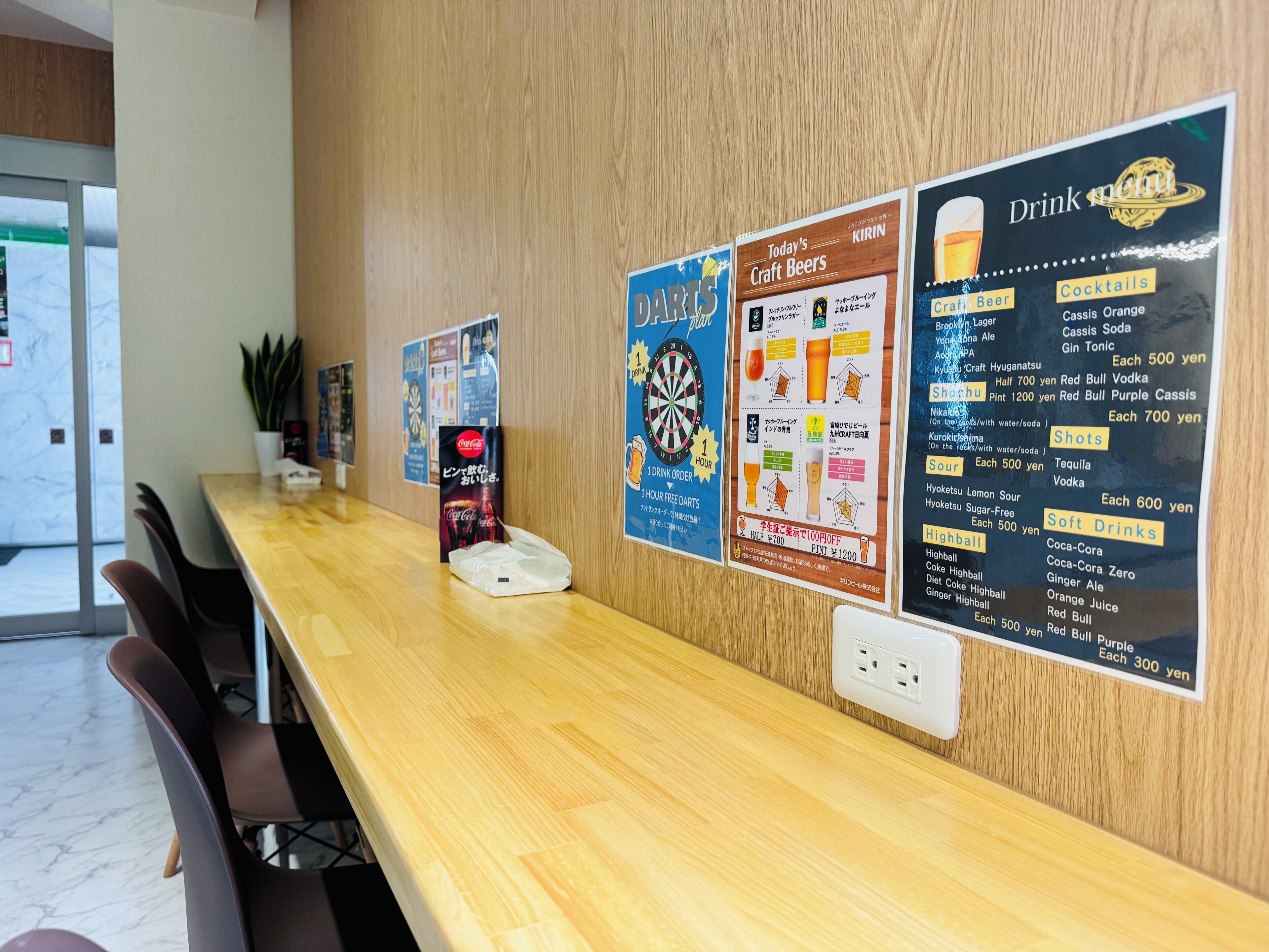 A wooden reception desk with a menu board displaying drink options and prices.