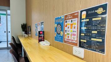 A wooden reception desk with a menu board displaying drink options and prices.