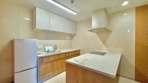 Eine moderne Küche mit Kühlschrank, Spüle und Holzschränken.