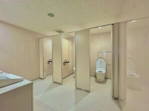 Une salle de bain moderne avec des toilettes, un lavabo et un miroir.