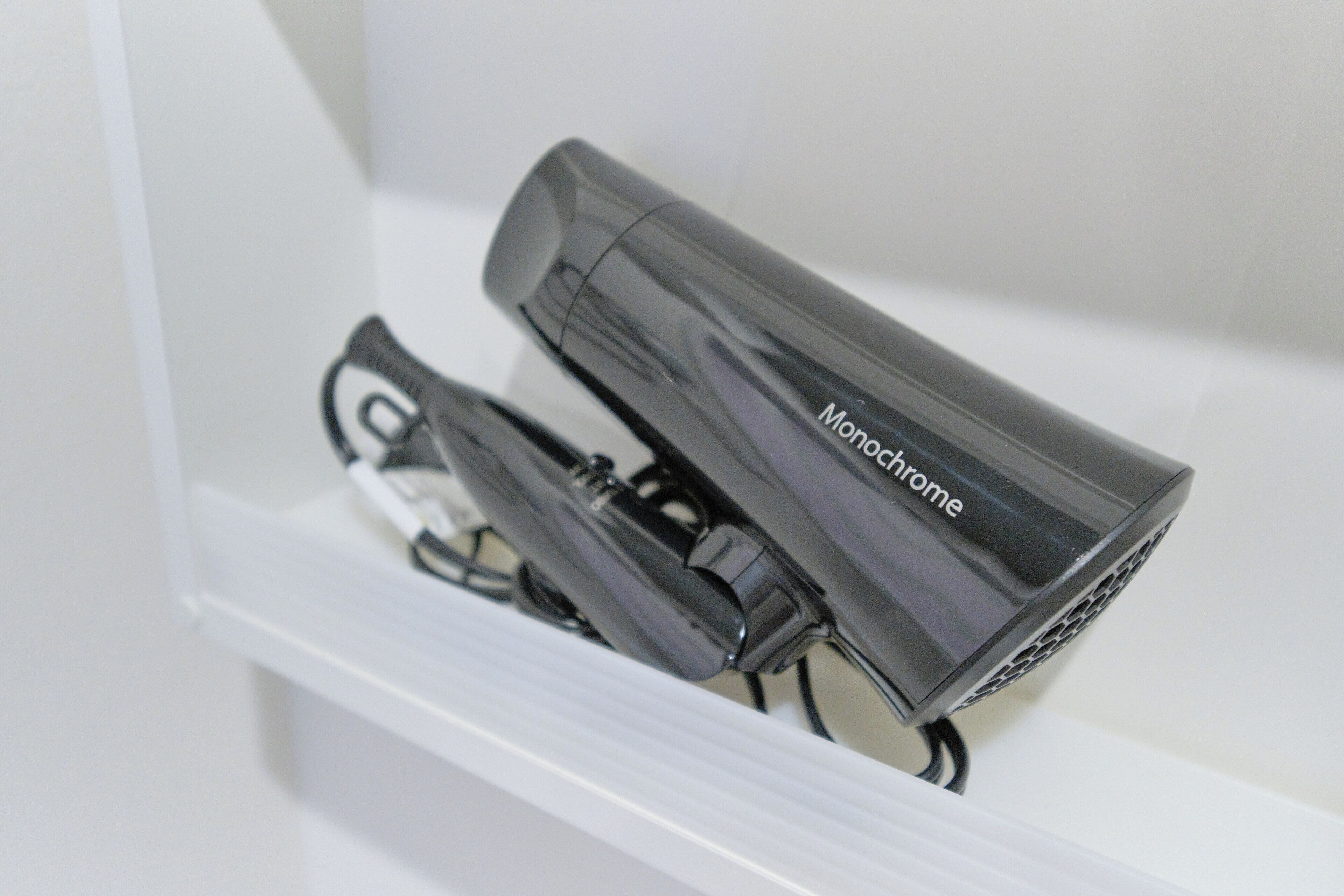 A black Monochrome device on a white shelf.