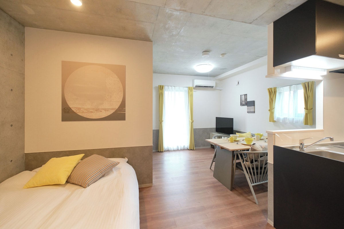 A hotel room with a bed, a desk, a chair, a television, and a bathroom.