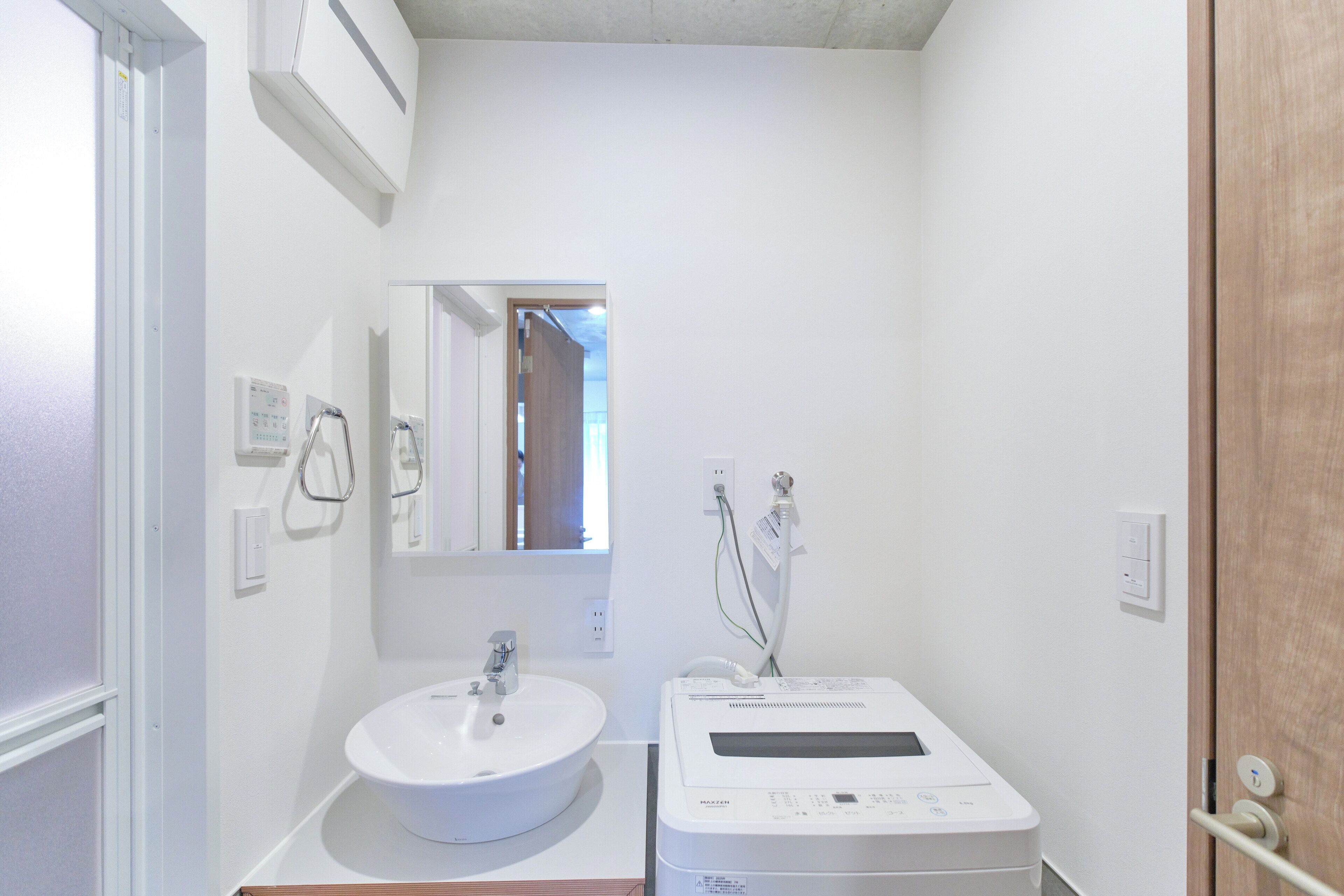 Une salle de bain avec un lavabo blanc, un miroir et un radiateur électrique portable blanc.