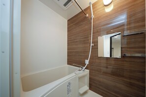 Combined shower/bathtub, hair dryer, slippers, towels