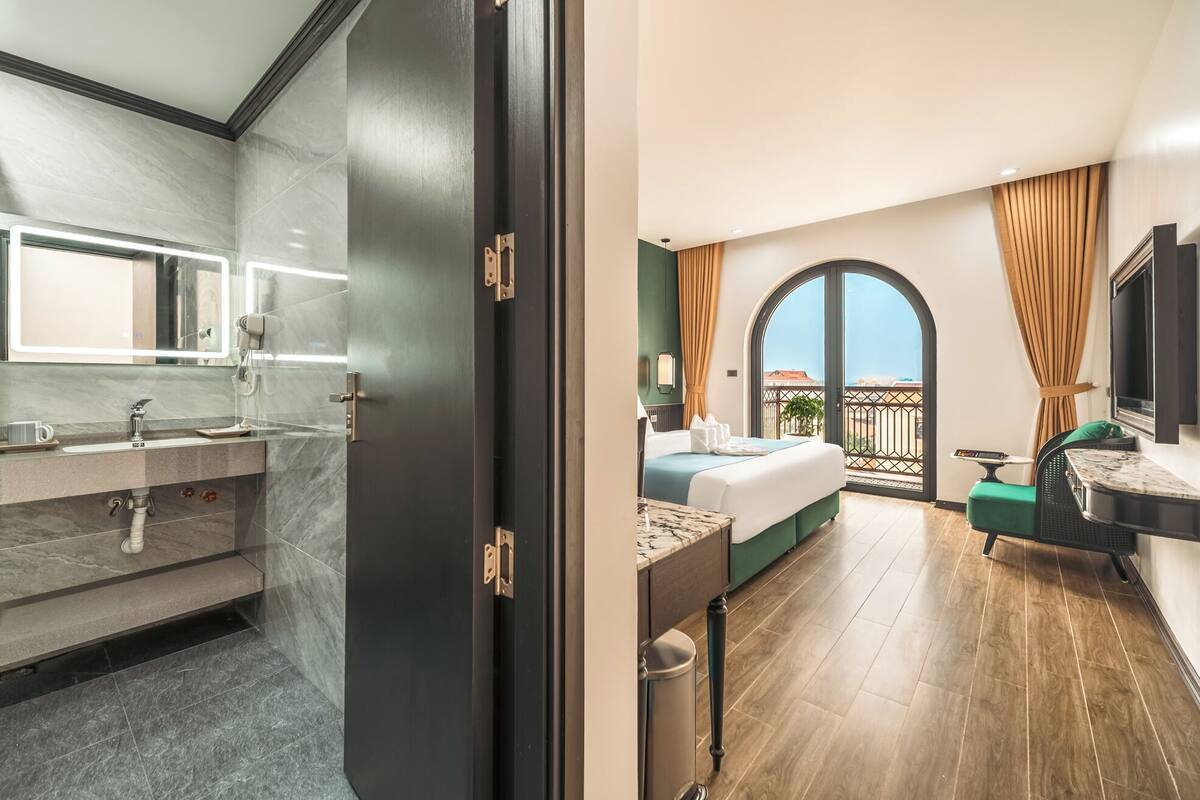 A modern bathroom with a large mirror, a vanity, and a shower area.