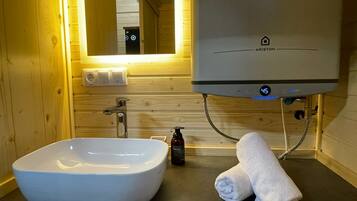 A bathroom with a white sink, a towel, and a water heater.