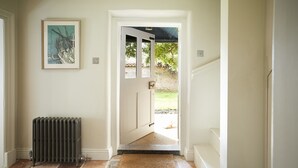 A hallway with a radiator, a framed picture on the wall, and a rug on the floor.