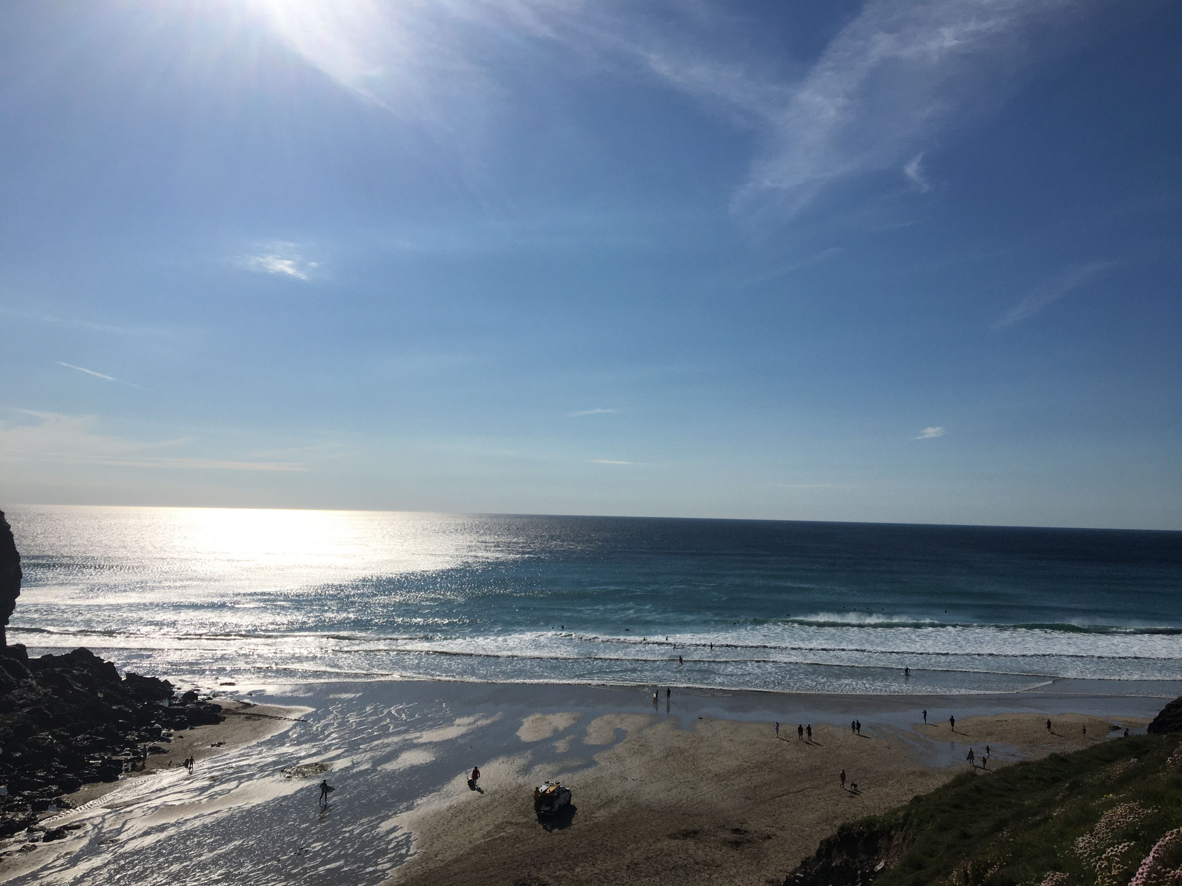Een strand met mensen die wandelen en een heldere lucht.