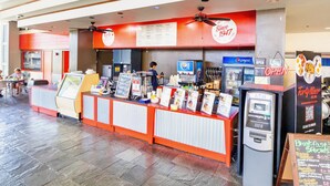 A fast-food restaurant with a counter, menu boards, and an ATM.