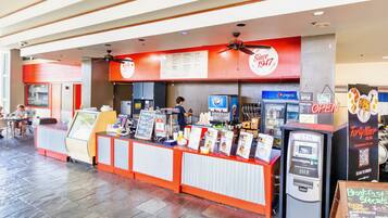 A fast-food restaurant with a counter, menu boards, and an ATM.