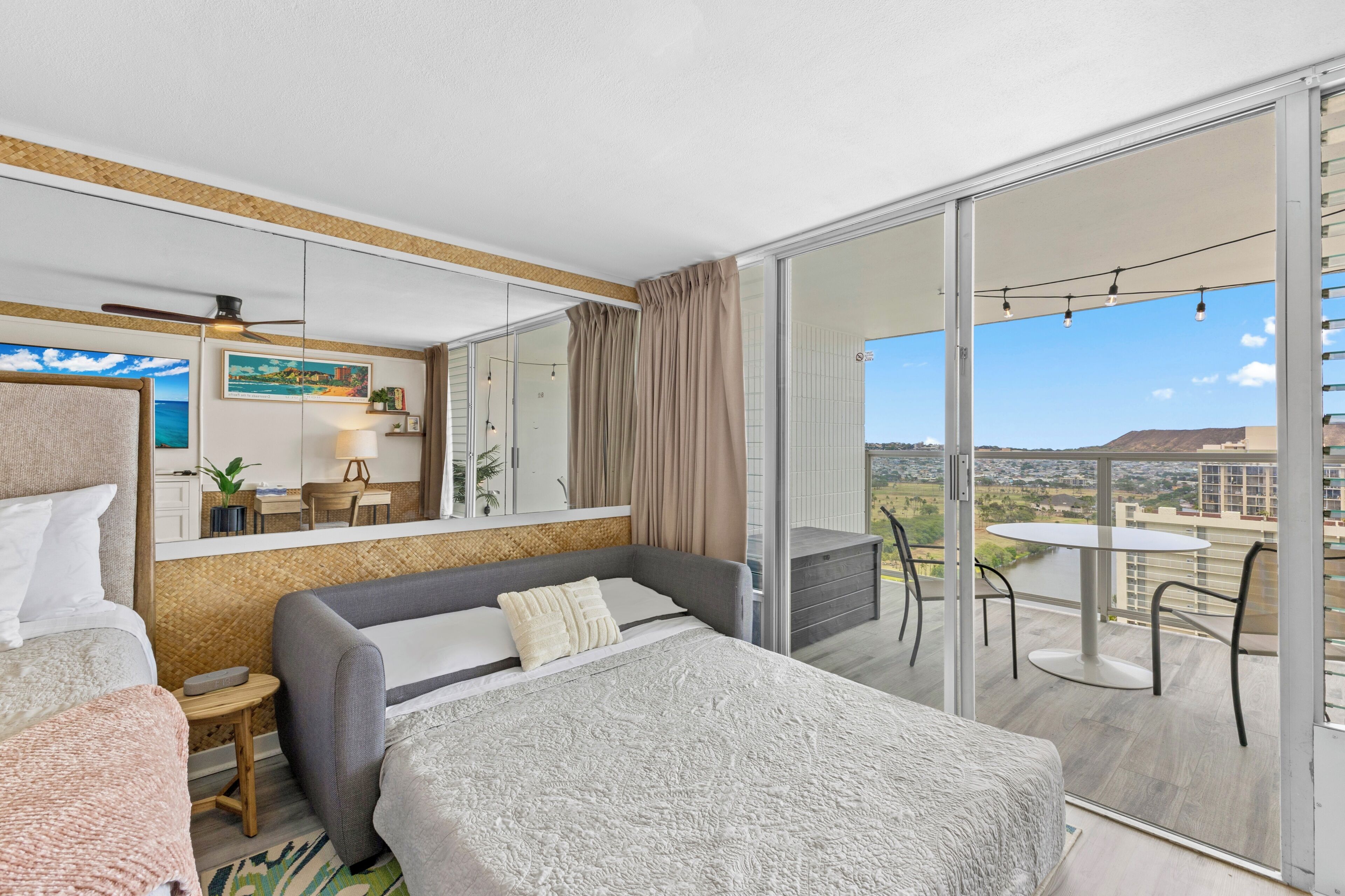 Ein Hotelzimmer mit Balkon, einem Bett, einer Couch, einem kleinen Tisch und einem Sessel.