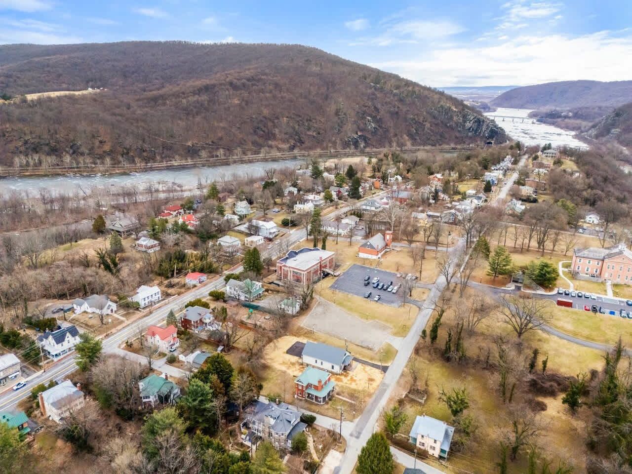 A residential area with houses, a large building, and a river.