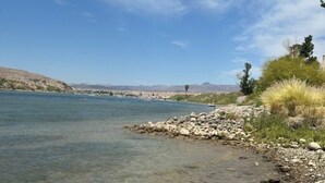 Un río claro con rocas visibles y vegetación escasa en sus orillas.