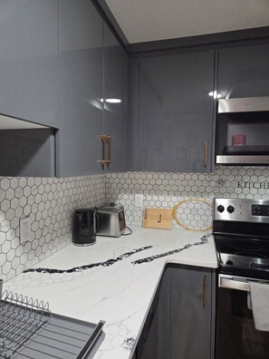 Een microgolfoven, een oven, een kookplaat, een vaatwasser