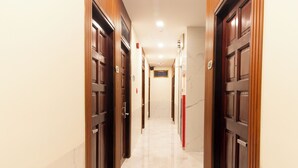 A corridor with wooden doors and marble flooring. - Atana Saigon Boutique Hotel II (Ho Chi Minh City)