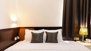 A hotel room with a neatly made bed, a bedside lamp, and a telephone on the nightstand. - Atana Saigon Boutique Hotel II (Ho Chi Minh City)