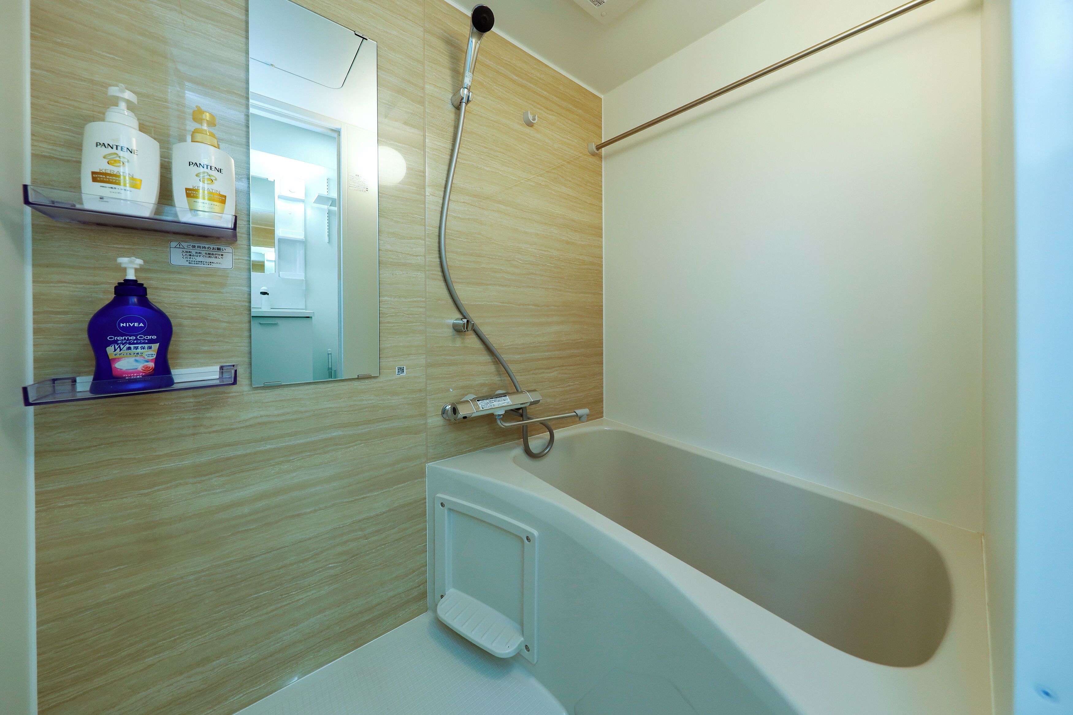 A modern bathroom with a bathtub, a shower, and a vanity with shelves holding toiletries.