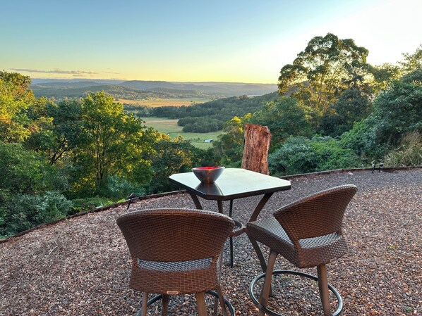 A patio with wicker chairs and a table overlooking a scenic landscape. - RiverRock Retreat Maroochy, Sunshine Coast: 6 bed 6, bath, 15 min from beach (Maroochy river)