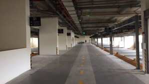 A covered parking area with concrete floors and yellow directional lines. - Le Indochina Hotel by AHH Group (Da Nang)