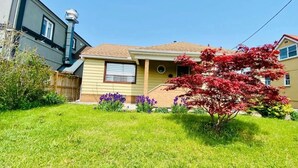 A residential house with a front yard, a garage, and a red-leaved tree. - Three Bedroom Bungalow with free parking, closer to commercial area and highway (Mississauga)
