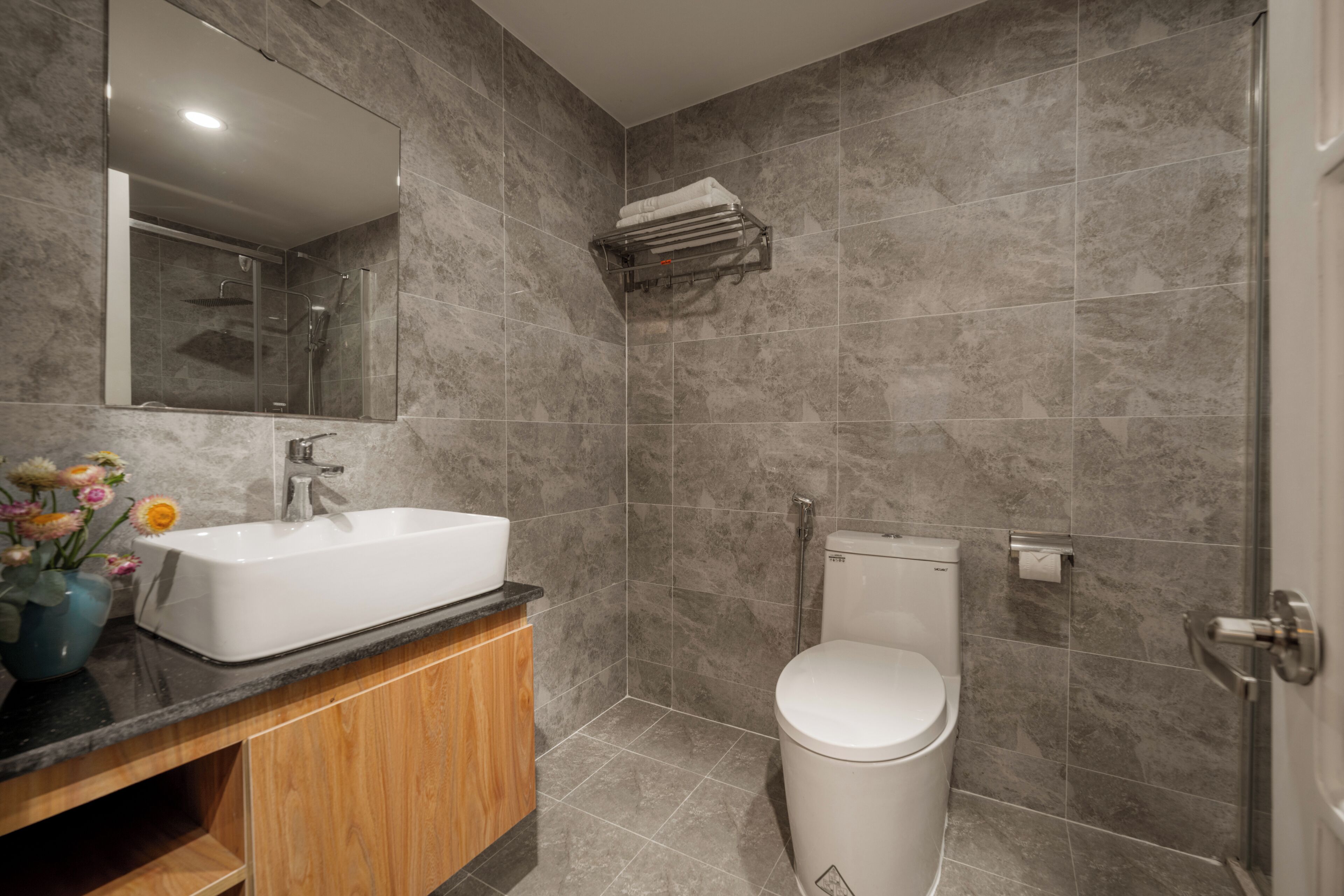 A modern bathroom with a rectangular sink, a toilet, and a shower area.