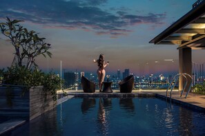 A pool area with a city skyline view, two lounge chairs, and a table. - Rest Hotel & Apartment Riverside Da Nang (Da Nang)