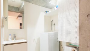 A modern bathroom with a white sink, mirror, and toilet.