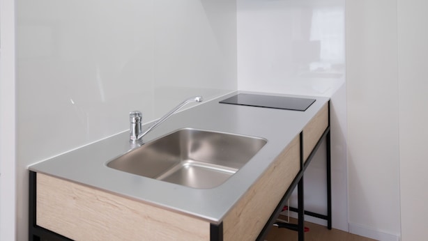 A kitchen with a stainless steel sink, a wooden countertop, and a black metal support structure. - Yamamoto Building by Tranova (Tokyo)