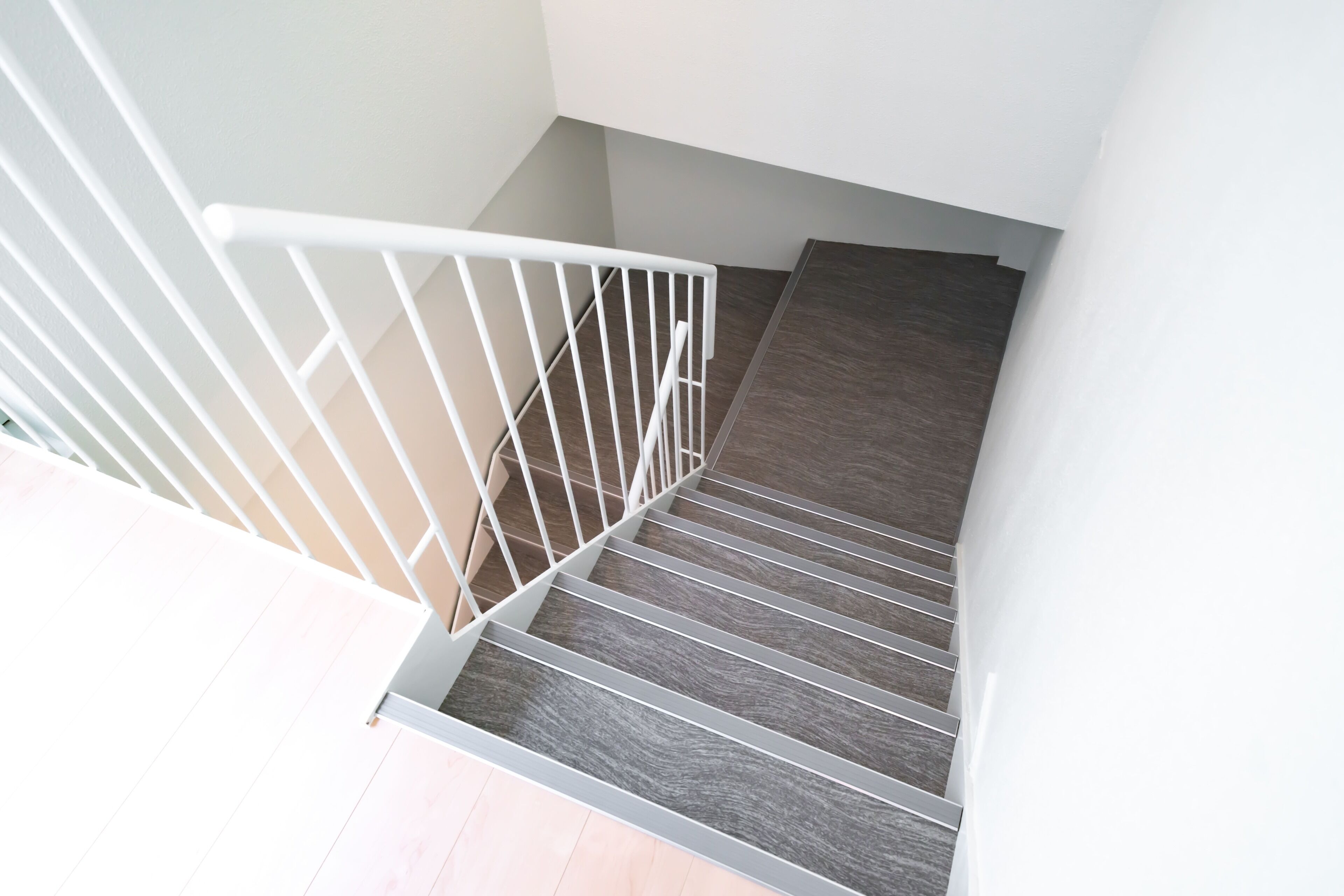 Una escalera con barandilla blanca y escalones de madera.